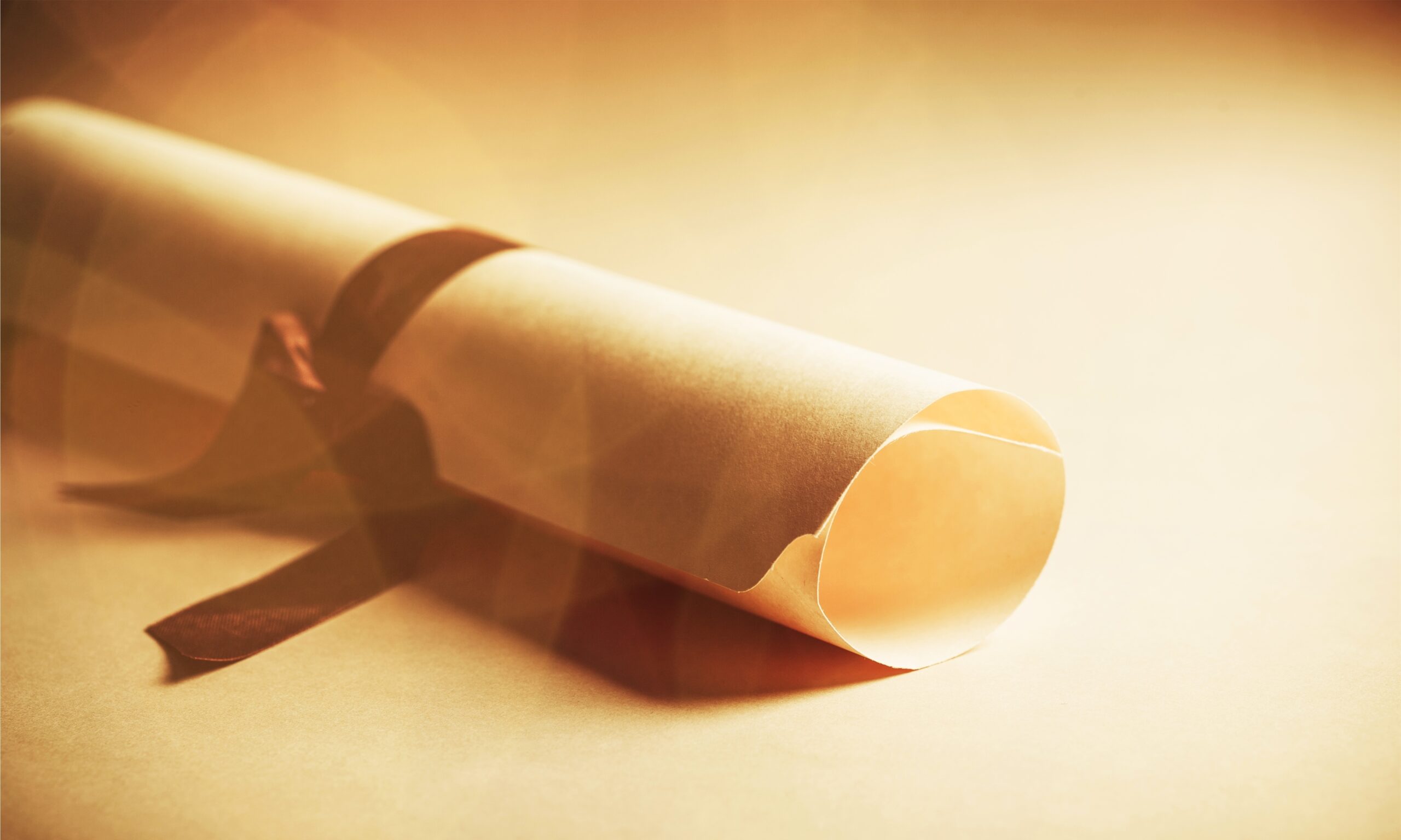 Diploma tied with brown ribbon beige on background Qualified Accreditation Consultants